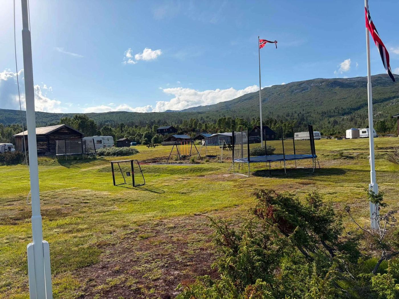 Children's play area with trampoline and swings at Stuttgången Camping in the evening sun